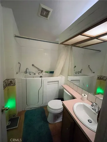 a bathroom with a granite countertop toilet sink and mirror