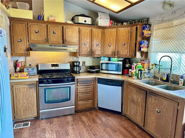 a kitchen with stainless steel appliances granite countertop a sink stove and cabinets