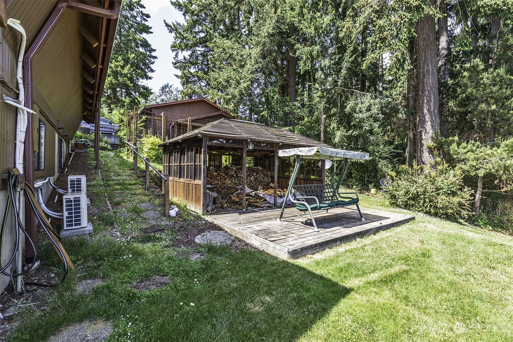 14125 Lyle Point Road Anderson Island, WA 98303 - Photo 29 of 38 a view of patio with table and chairs under an umbrella with large trees