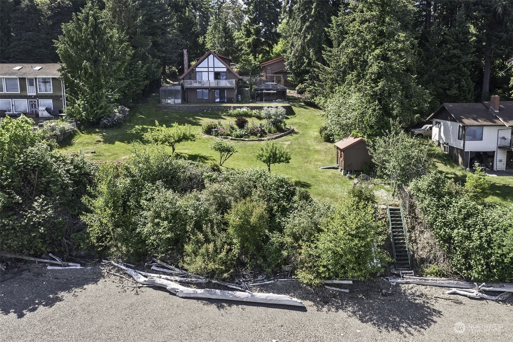 14125 Lyle Point Road Anderson Island, WA 98303 - Photo 4 of 38 a view of a house with a small yard and large trees