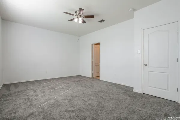 an empty room with chandelier fan
