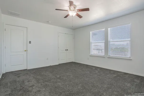 a view of a room with a ceiling fan and a window