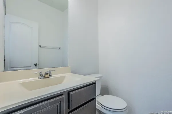 a bathroom with a sink a toilet and a mirror