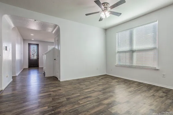 a view of an empty room with a window and wooden floor