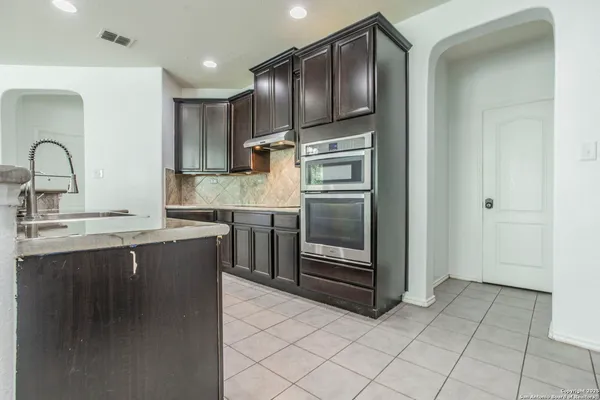 a kitchen with stainless steel appliances granite countertop a refrigerator and a sink