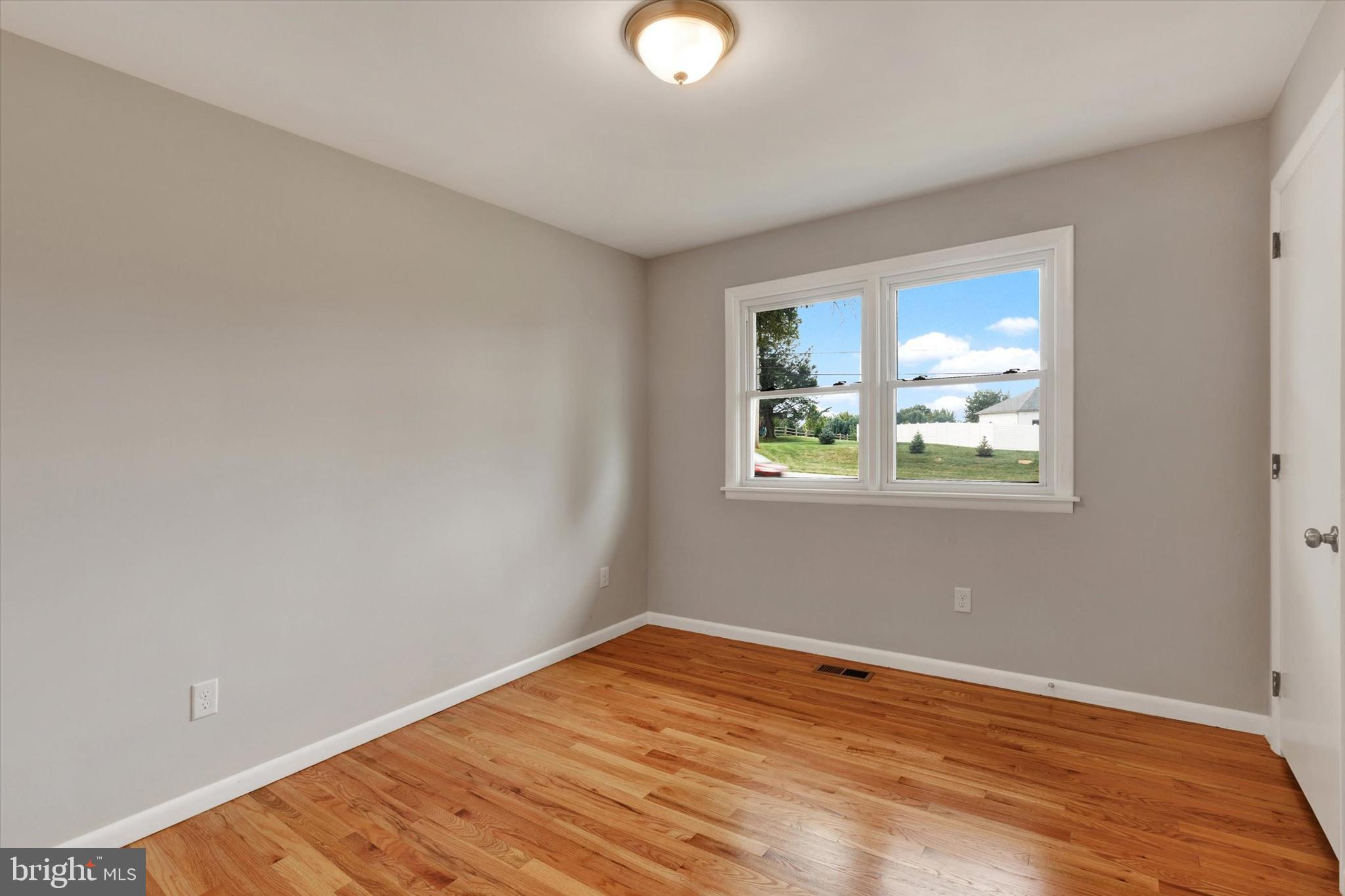 1227 Lebanon Road Manheim, PA 17545 - Photo 17 of 31 a view of an empty room with wooden floor and a window