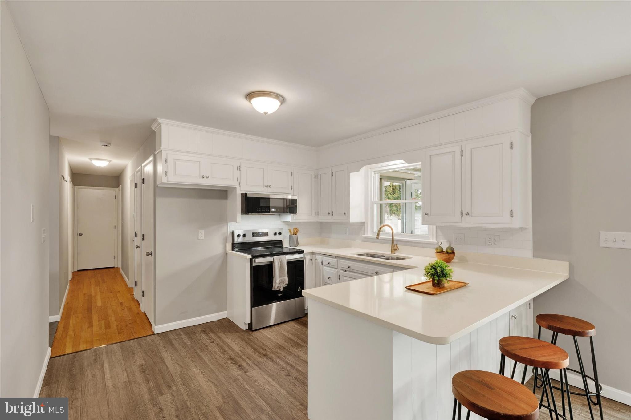 1227 Lebanon Road Manheim, PA 17545 - Photo 5 of 31 a kitchen with a sink a stove and chairs