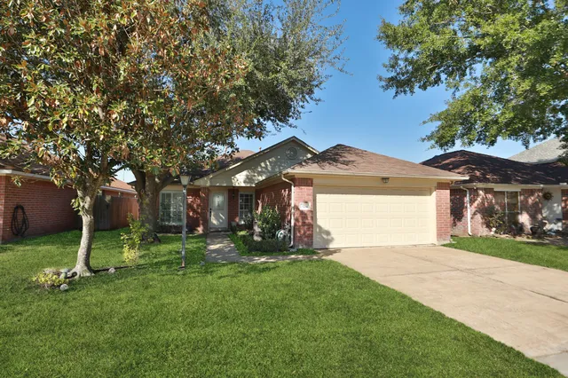 a front view of a house with a yard and tree