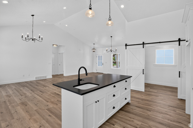 Kitchen island with a black countertop and integrated sink, complemented by wood-finish flooring