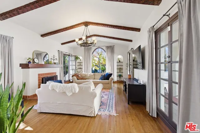 a living room with fireplace furniture and a large window
