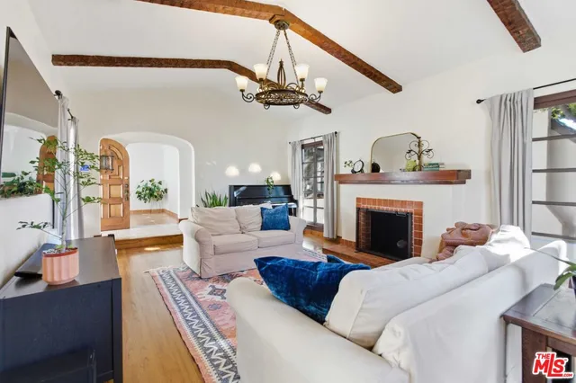 a living room with furniture a fireplace and a large mirror