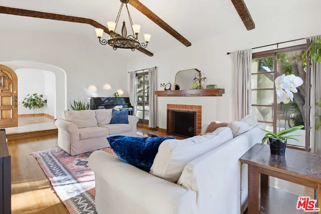 a living room with furniture a chandelier and a fireplace