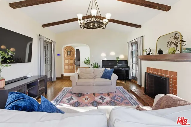a living room with furniture a chandelier and a fireplace