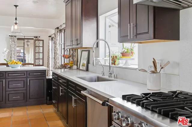 a kitchen with stainless steel appliances a sink stove and cabinets