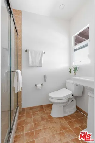 a bathroom with a toilet and a shower