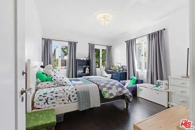 a bedroom with a bed table flowerpot and window