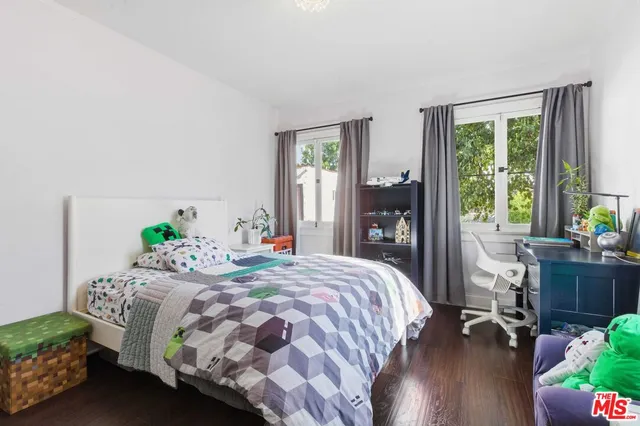 a bedroom with a bed and large windows