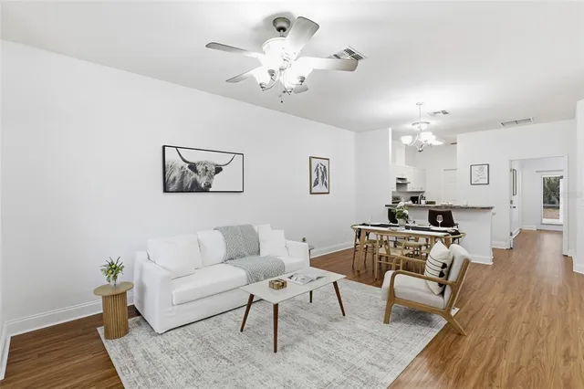 a living room with furniture dining table and a chandelier