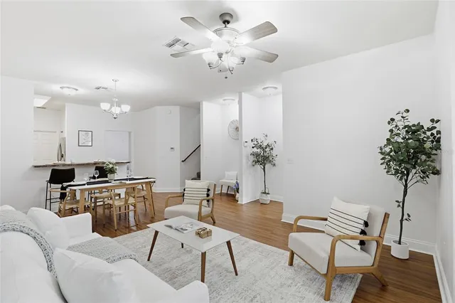 a living room with furniture a chandelier and a dining table