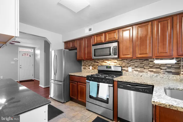 a kitchen with stainless steel appliances granite countertop a stove a refrigerator and a sink