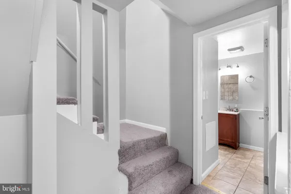 a view of a hallway with bathroom and a glass door