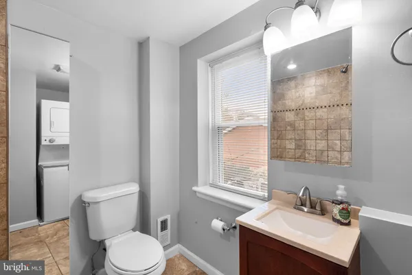 a bathroom with a sink vanity mirror and toilet