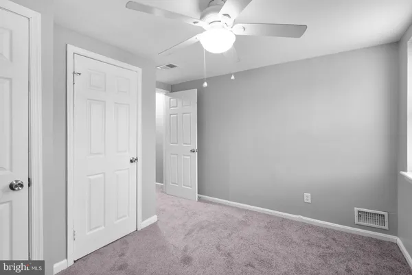 a view of an empty room and a ceiling fan window
