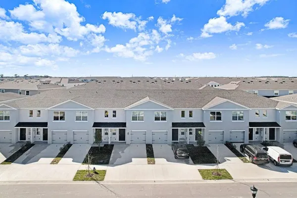 a view of a big house with large windows and a yard
