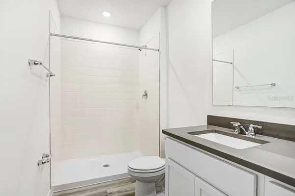 a bathroom with a granite countertop sink toilet and shower
