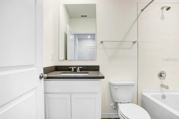 a bathroom with a sink toilet vanity and bathtub