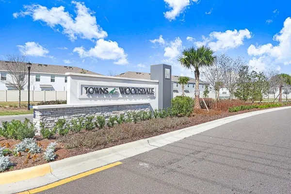 a view of a building with a yard and large trees