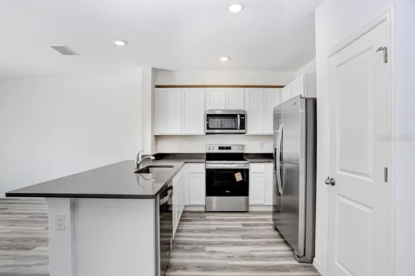 a kitchen with stainless steel appliances a refrigerator sink and stove