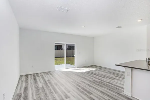 a view of an empty room with wooden floor and closet