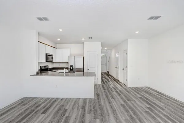 a large white kitchen with stainless steel appliances
