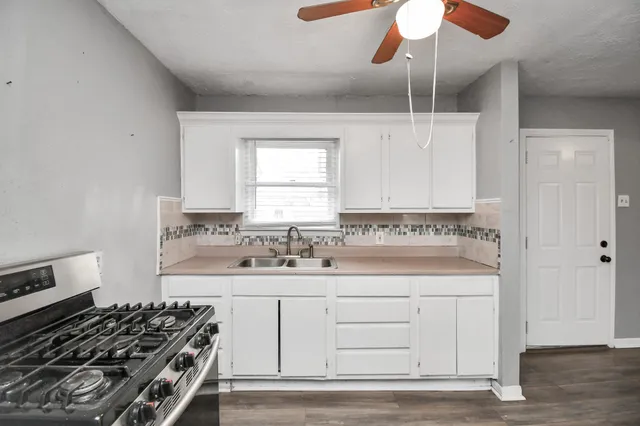 a kitchen with white cabinets and appliances