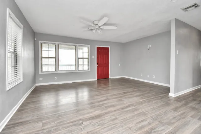 wooden floor in an empty room with a window