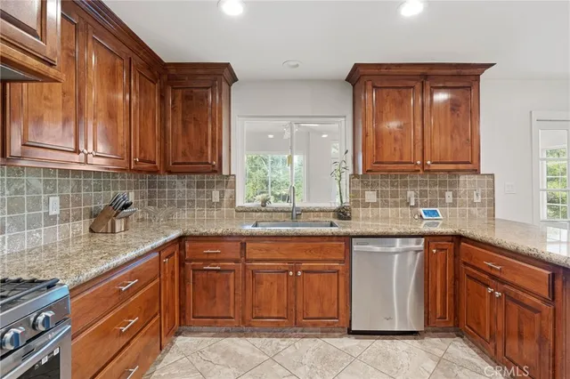 a kitchen with stainless steel appliances granite countertop a sink stove and cabinets