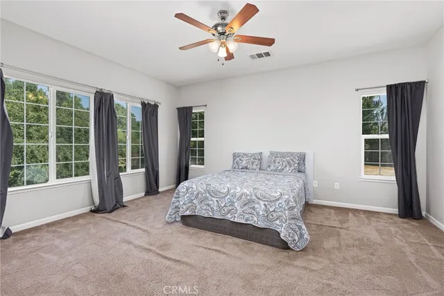 a spacious bedroom with a bed and a large window