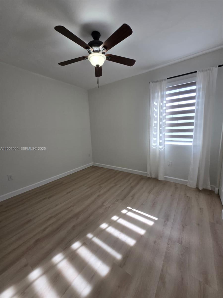 4268 Southwest 166th Court, Unit 4268 Miami, FL 33185 - Photo 13 of 21 a view of an empty room with wooden floor and a window