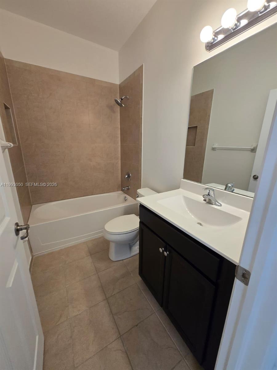 4268 Southwest 166th Court, Unit 4268 Miami, FL 33185 - Photo 16 of 21 a bathroom with a sink a toilet a mirror and bathtub