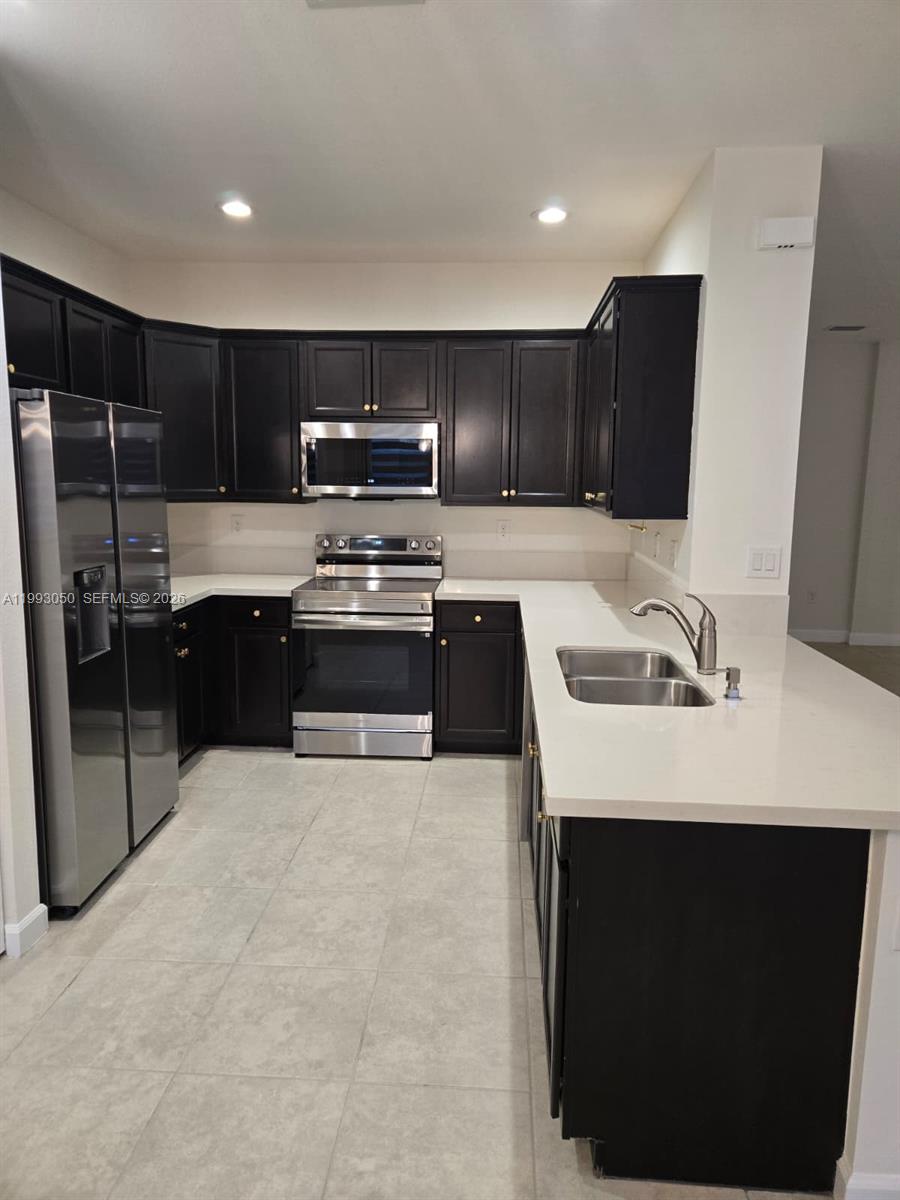 4268 Southwest 166th Court, Unit 4268 Miami, FL 33185 - Photo 4 of 21 a kitchen with kitchen island stainless steel appliances a sink stove and refrigerator
