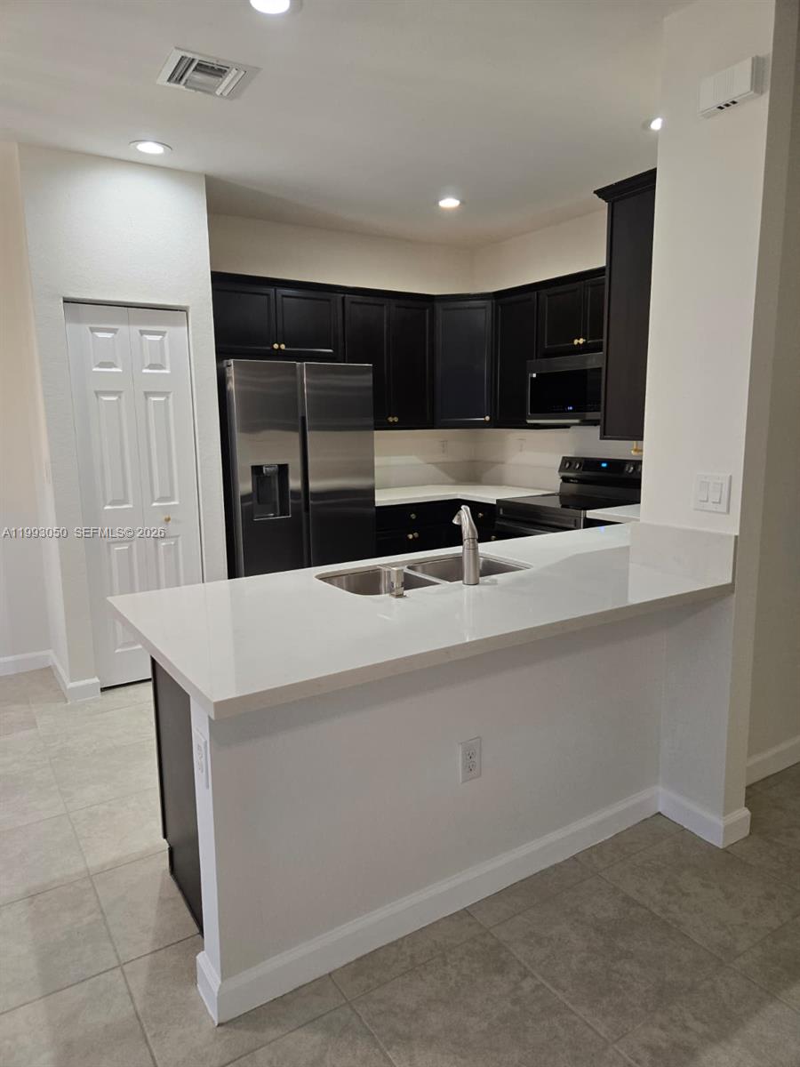 4268 Southwest 166th Court, Unit 4268 Miami, FL 33185 - Photo 5 of 21 a kitchen with stainless steel appliances a sink and a refrigerator