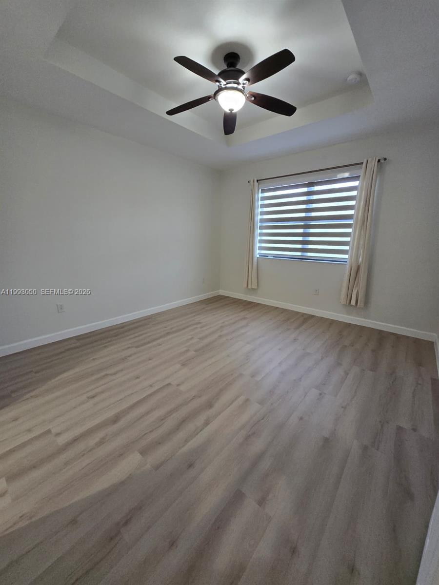 4268 Southwest 166th Court, Unit 4268 Miami, FL 33185 - Photo 10 of 21 an empty room with wooden floor and windows