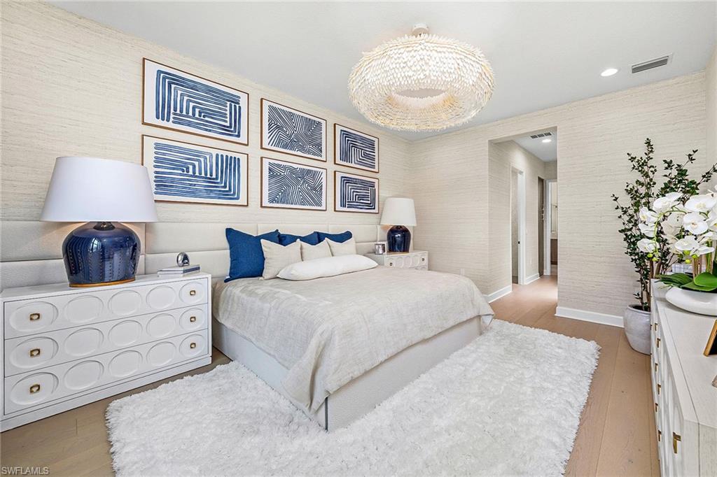 12777 Springbrook Court Estero, FL 33928 - Photo 8 of 27 a bedroom with a large bed and a chandelier