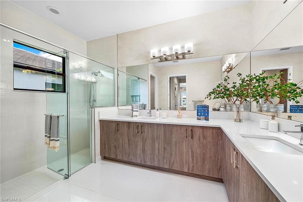 12777 Springbrook Court Estero, FL 33928 - Photo 10 of 27 a spacious bathroom with a double vanity sink a mirror and a shower