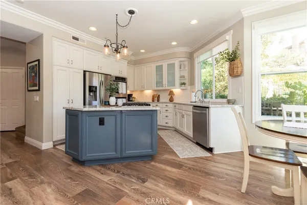 a kitchen with stainless steel appliances granite countertop a sink a stove and a refrigerator