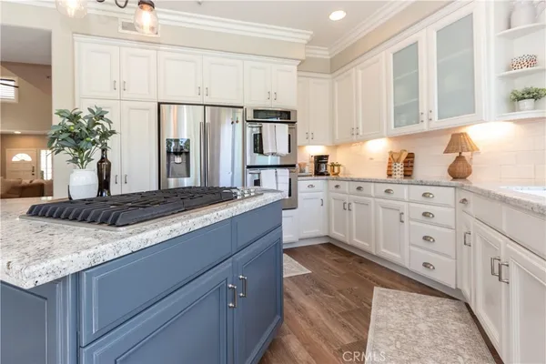 a kitchen with granite countertop white cabinets white appliances a sink and a large window