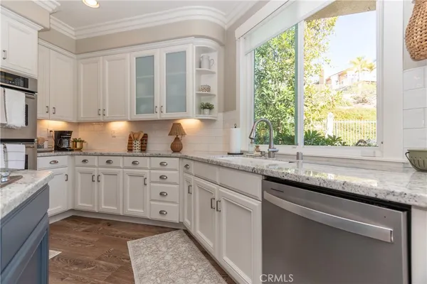 a kitchen with granite countertop a sink appliances cabinets and dining table