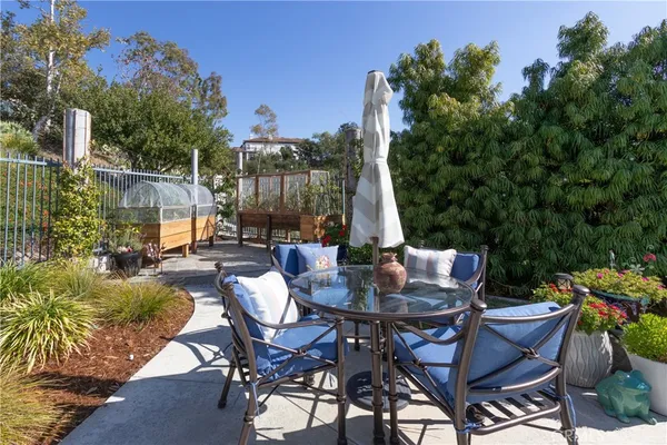 a view of a patio with table and chairs potted plants and a large tree