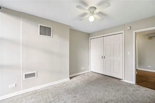 a view of a big room with closet and a ceiling fan